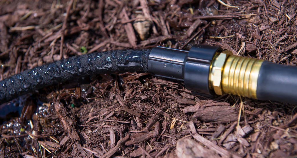 A coiled soaker hose placed around the drip line delivers slow, even moisture directly to the root zone, making it one of the simplest and most cost-effective deep watering methods.